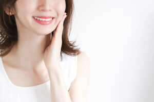 笑顔で頬を押さえる女性