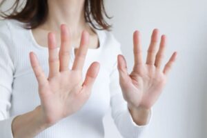 両手の平を前に突き出す女性